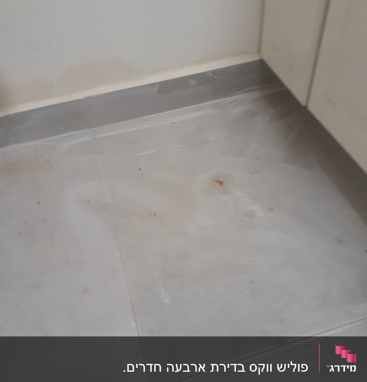 רצפה מלוכלכת עם כתמים ואבק ליד ארון